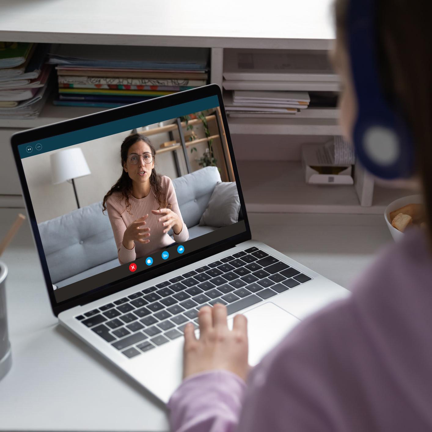 Student working remotely with a tutor on a laptop computer.