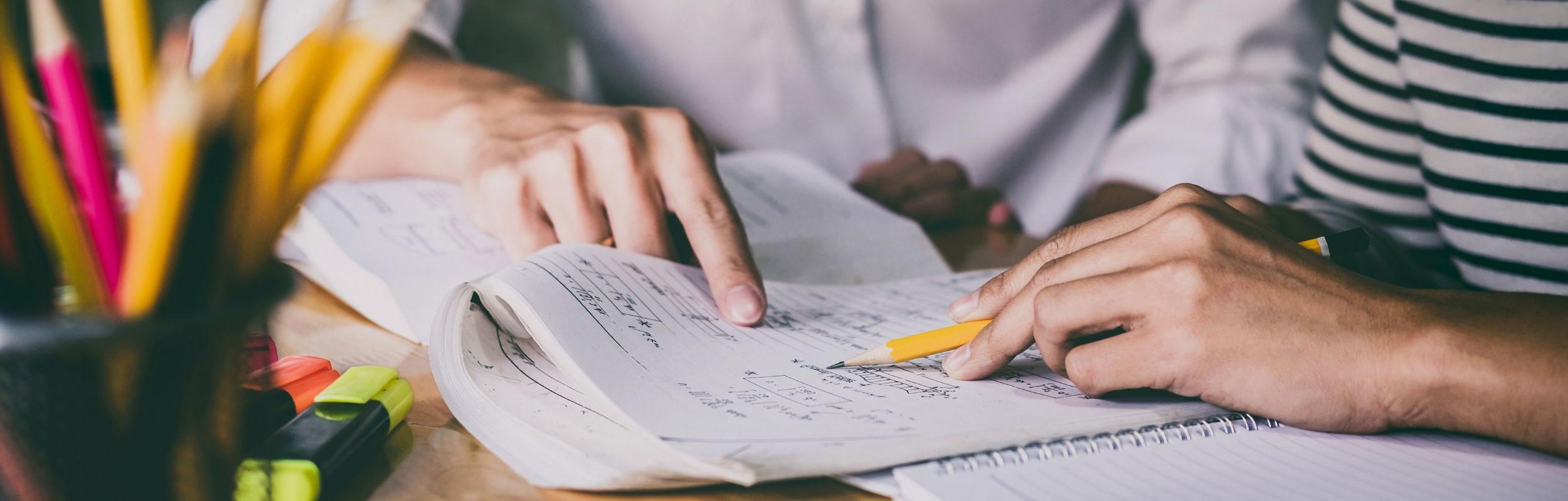 Close up of two people working on a math equation.