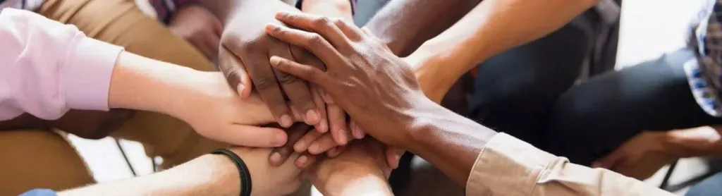 A group of students stacking their hands